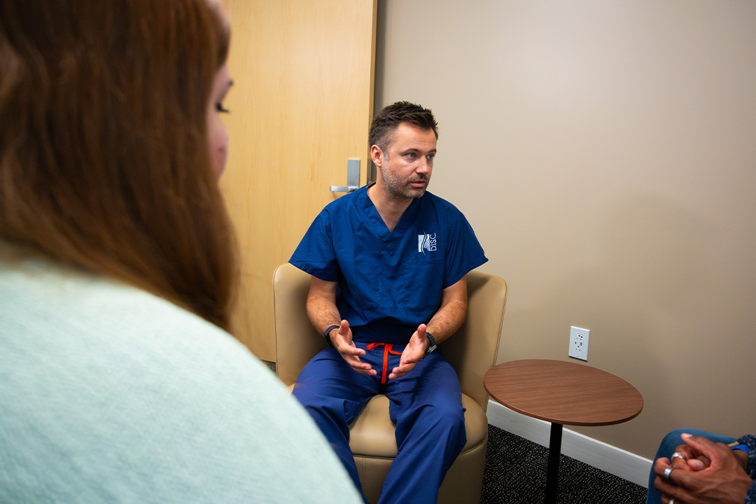 Dr. Luke Macyszyn listening to patient