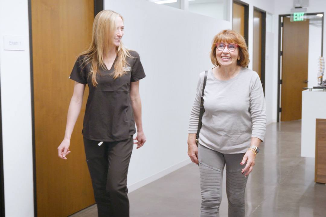 Nurse walking with patient through hallway