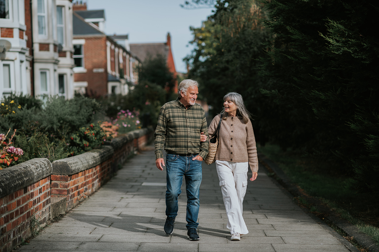 mature couple walking along residential area