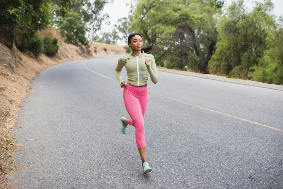 young woman running along road