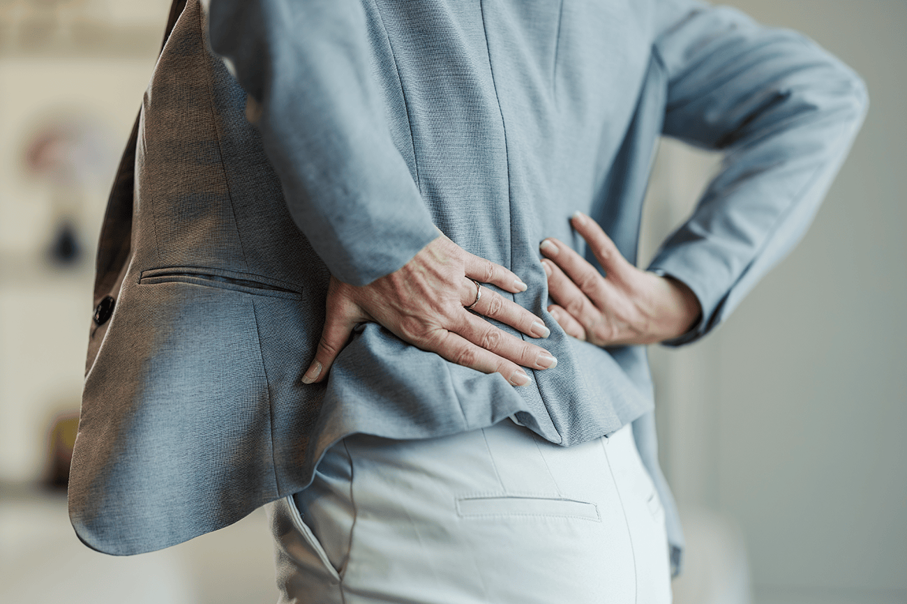 Office woman holding her back in pain
