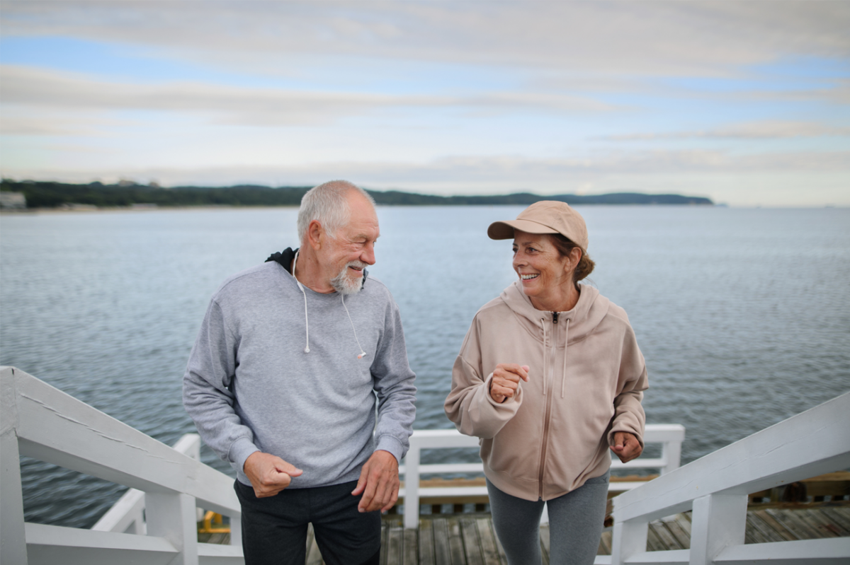 mature couple walking up beach stairs